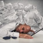 Businessman with a pile of sheets over his head