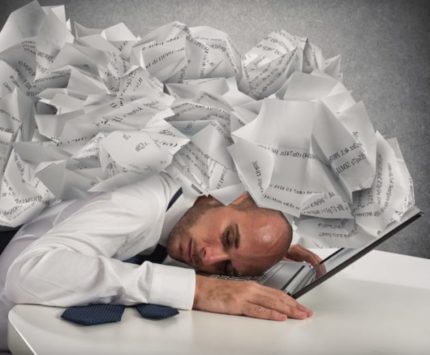 Businessman with a pile of sheets over his head